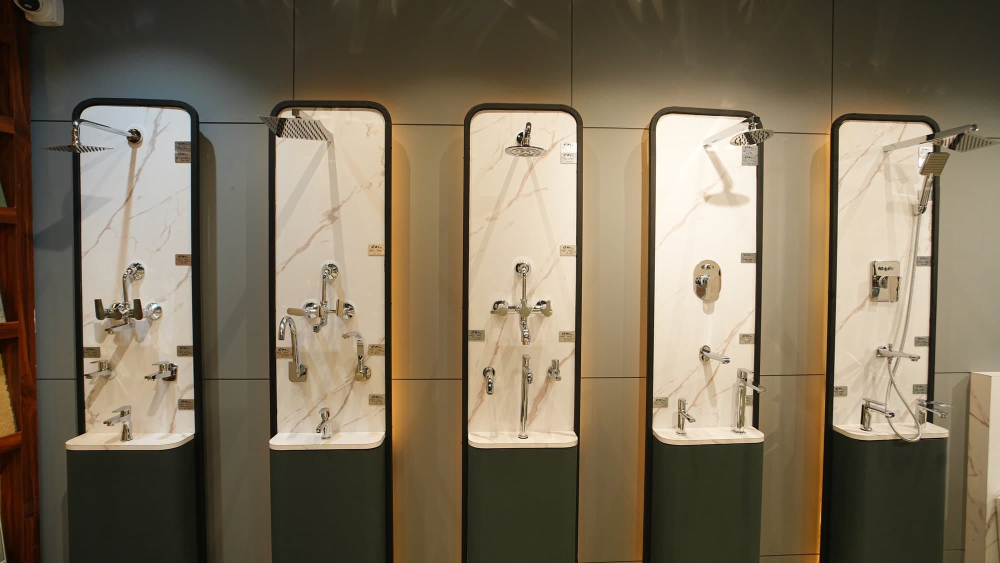 A row of shower and faucet panel displays at Star Tiles